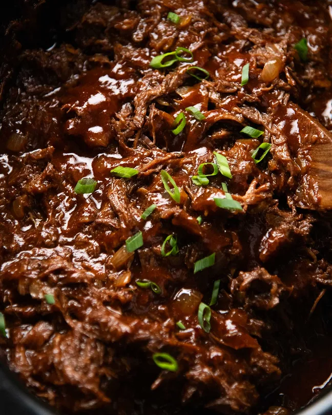 Slow Cooker BBQ Shredded Beef is what you make when you want a big batch of crowd-pleasing food with relatively little effort. The succulent pulled beef is smothered in an incredible homemade barbecue sauce, and there’s so many ways to serve it – pile into slider s, heap onto plates or stuff into baked potatoes! 1